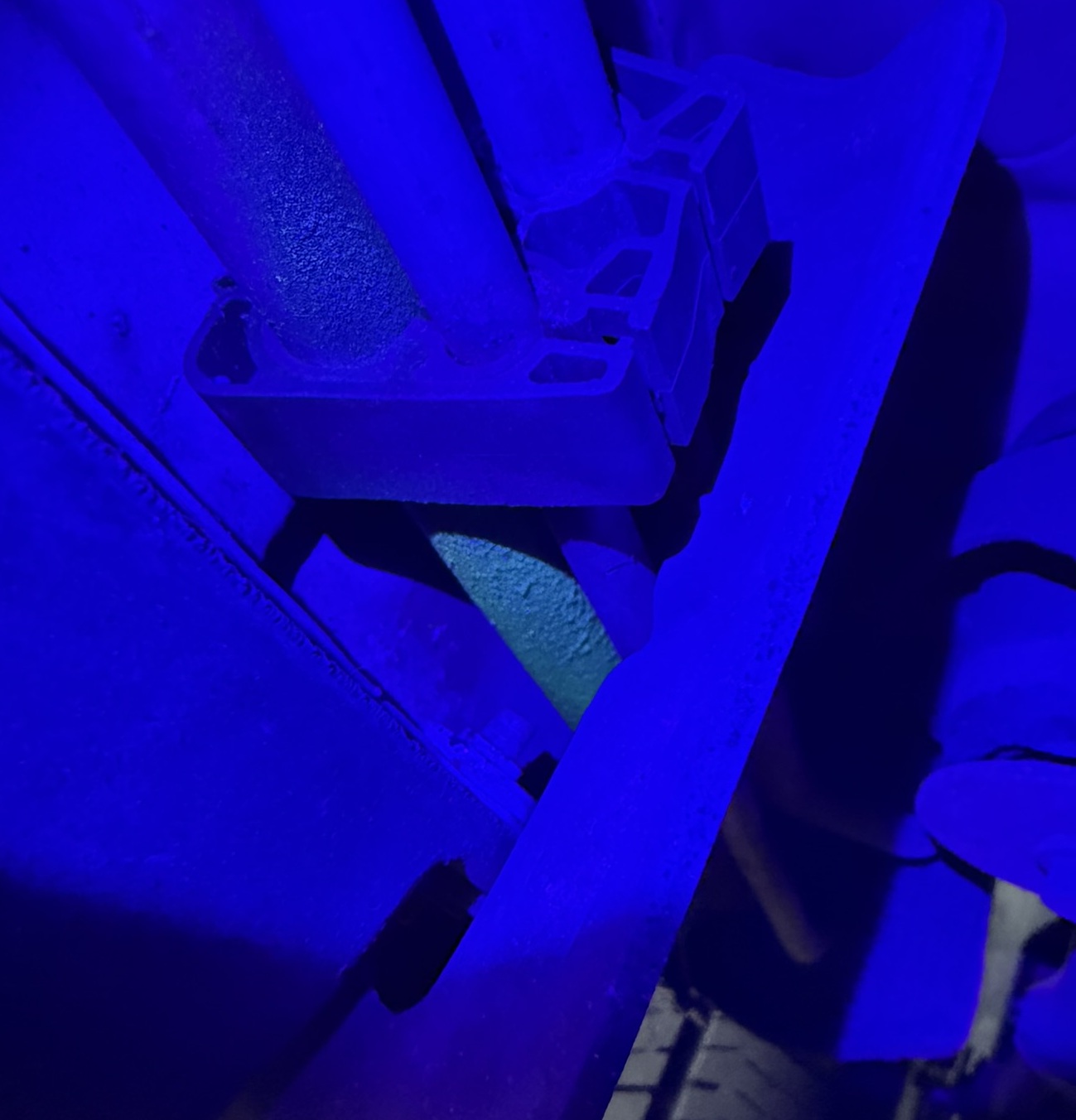 UV dye glowing neon at the exact point of an A/C refrigerant leak under ultraviolet light
