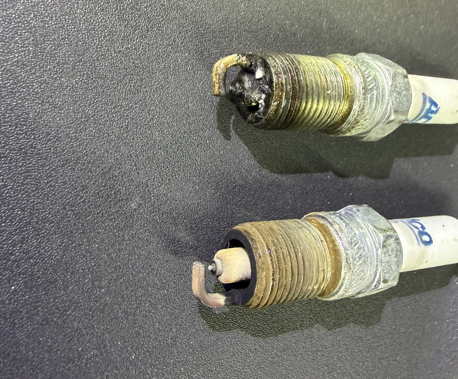 A fouled spark plug pulled during diagnosis — evidence of an underlying engine problem